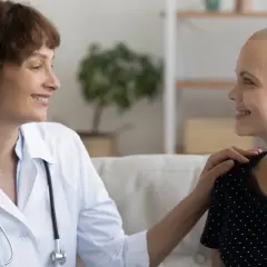 Ärztin tröstet Patientin, die ihre Haare wegen Chemotherapie verloren hat. Hoffnungsvolles Gespräch über die Chemotherapie Dauer.