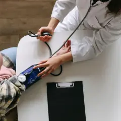 Arzt misst Blutdruck bei Patientin. Ein Beispiel für integrative Onkologie, die ganzheitliche Betreuung in den Vordergrund stellt.