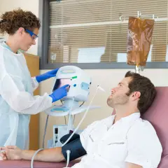 Eine Krankenschwester überwacht die Vitalwerte eines Patienten während einer Chemotherapie. Die Frage, welche Chemo am schlimmsten ist, beschäftigt viele.